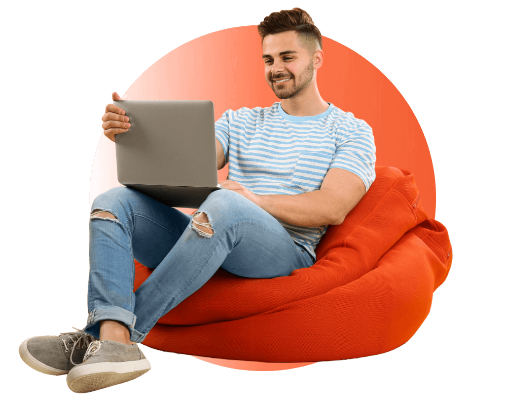 male student using laptop while sitting on bean bag